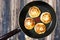 Pancakes in a frying pan on a wooden texture, top view. Just cooked hot cheesecakes. Top view.