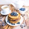 Pancakes healthy breakfast with blueberries, bog whortleberry, cup of green tea, cup of blueberries and teapot