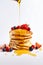 Pancakes with Honey and Fresh Fruits on White Background. Generative ai