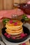 Pancakes hotcakes with berries and fruit, a man pouring maple syrup on stack