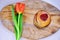 Pancakes with jam and flower. A red tulip lies next to the pastries on the kitchen Board. A hill of fresh pancakes on the table in