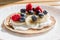 Pancakes with raspberries, blueberries, bananas and honey. Healthy summer breakfast, homemade classic american pancakes.