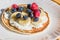 Pancakes with raspberries, blueberries, bananas and honey. Healthy summer breakfast, homemade classic american pancakes.