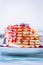 Pancakes with red fruits stacked with raspberry jam on a white plate