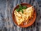 Pancakes with salted trout and basil leaves on a ceramic plate