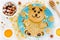 Pancakes in the shape of cute bear with honey and nuts for kids