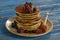 Pancakes stacked. Raspberry and black currant are sprinkled. Poured with honey