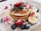 Pancakes with strawberry, banana, blue berry,icing sugar topping