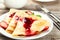 Pancakes with strawberry on plate on a grey wooden backgound