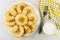 Pancakes in white dish, cup of milk, napkin and fork