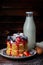 Pancakes with wild berries and cream on dark background.