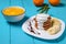 Pancakes with yogurt and banana pieces, orange juice.