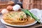Pancakes with young green onions on a wooden background
