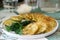 Pancakes with zucchini and sweet corn, served with sour cream, parsley and dill. Vegetarian food.