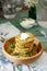 Pancakes with zucchini and sweet corn, served with sour cream, parsley and dill. Vegetarian food.