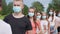 Pandemic concept. A group of students stand in a row in masks.