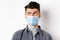 Pandemic lifestyle, healthcare and medicine concept. Confused guy in face mask look left at logo and frowning skeptical