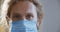 Pandemic portrait of young handsome man with blue eyes wearing protective medical mask, concept health and safety