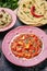 Paneer Makhani, Jeera Rice and paratha in pink plate on dark background