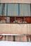 Panel wall of abandoned administrative building with broken glass in windows and boarded up with rusty metal plates