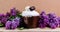 Panettone Easter baked goods are decorated with icing on a background of spring lilac flowers