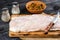 Pangasius fillet on a wooden cutting board with spices and knife on a black wooden background