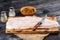 Pangasius fillet on a wooden cutting board with spices and knife on a black wooden background