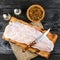 Pangasius fillet on a wooden cutting board with spices and knife on a black wooden background