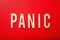 Panic word text wooden letter on red background