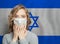 Panicked woman wearing a face mask on national flag Israel background. Flu epidemic and virus protection concept