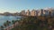 Panning aerial drone slowly flying over a colorful Honolulu Skyline while Sunset in Oahu, Hawaii with Waikiki Beach