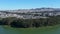 panning aerial footage of a beautiful summer landscape at Lake Merced with homes on the hillside blue lake water