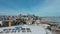 panning aerial footage of the Chase Center with the bay bridge over blue ocean water and skyscrapers and office buildings