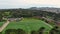 panning aerial footage of Golden Gate Park with people playing soccer on a soccer field, lush green trees, plants and grass