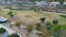 panning aerial footage of the people relaxing in the park with lush green trees and grass, railroad tracks and apartments