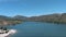 panning aerial footage of the rippling blue waters of Silverwood Lake with a beach and people swimming in the water