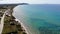 Panning beautiful aerial footage of the beach and coastal village of St George South in Corfu Greece showing the Agios Georgios