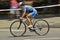 Panning of a beautiful girl riding bicycle in a sunny day, competing for Road Grand Prix event, a high-speed circuit race