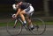 Panning of a beautiful girl riding bicycle in a sunny day, competing for Road Grand Prix event, a high-speed circuit race