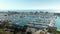 panning footage of the boats and yachts docked in the Dana Point Harbor with vast blue ocean water and lush green trees