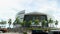 panning footage of the Kaseya Center arena with lush green palm trees and cars and trucks driving on the street, blue sky