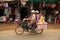 Panning of Four persons on motorbike passing Sra`aem Market in Preah Vihear province, Camb