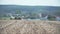 Panning shoot of tractor plowing field with harrows.