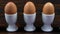 Panning shot across a row of boiled eggs to a single egg with a smiling face drawn on it