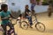 Panning shot of blurring and freezing effect of a girls chidren riding the bicycles.