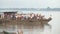 Panning shot of an crowded ferry boat drawing away from pier 