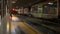 Panning shot: Railroad and train at night station in the rain, Biella, Italy