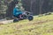 Panning shot of rider in blue on quad