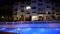 Panning of swimming pool at the luxury hotel in night illumination