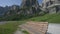 Panning view of Sass Ciampac Ciampatsch with a foreground of globeflower wildflowers Trollius europaeus in the Dolomites